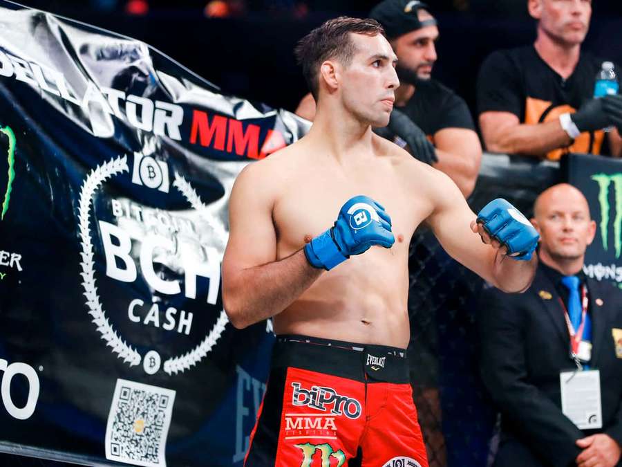 MMA fighter in red shorts and blue gloves standing in the ring. — Rory Macdonald Wallpaper