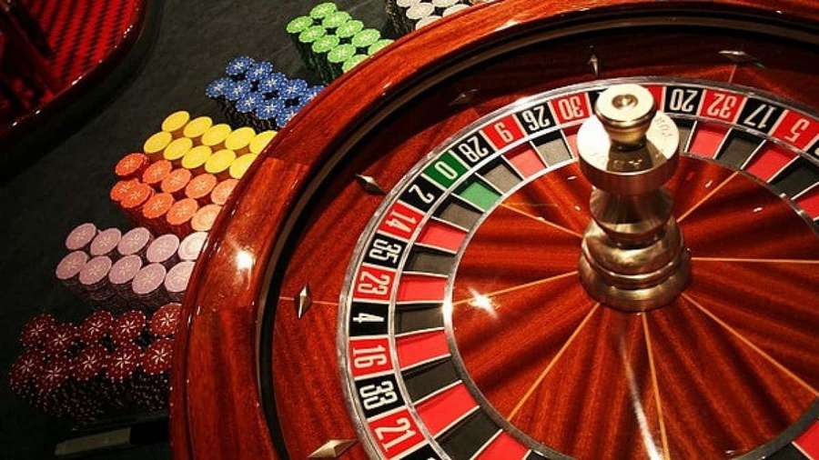 Roulette wheel with colorful chips arranged around it on a casino table. — Roulette Wallpaper