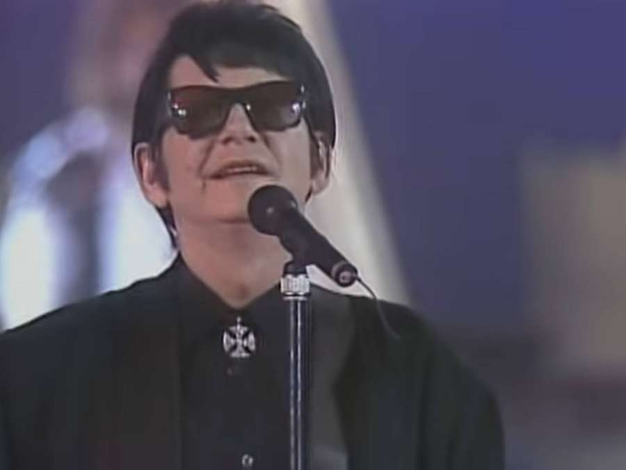Sänger mit Sonnenbrille tritt mit Mikrofon auf der Bühne auf — Roy Orbison Bilder
