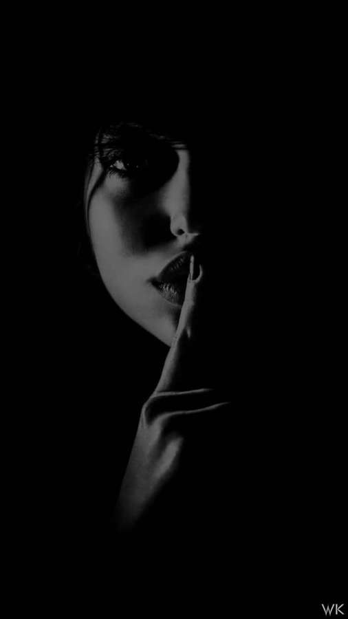 Frau im Schatten hält Finger an die Lippen in stiller Geste — Ruhig Wallpaper