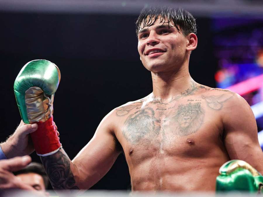 Boxer with lion tattoos celebrates victory in the ring holding up his glove. — Ryan Garcia Wallpaper