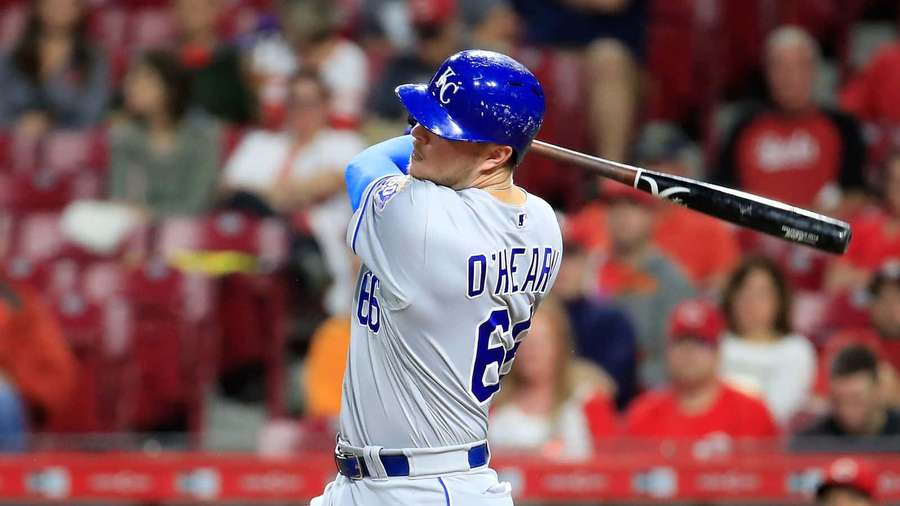 Baseballspiller svinger battet under en natkamp med publikum i baggrunden. — Ryan O'hearn Wallpapers
