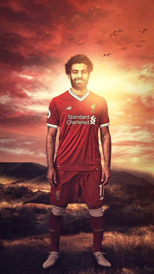 Football player in red Liverpool kit standing in sunset landscape with birds flying. — Salah Background