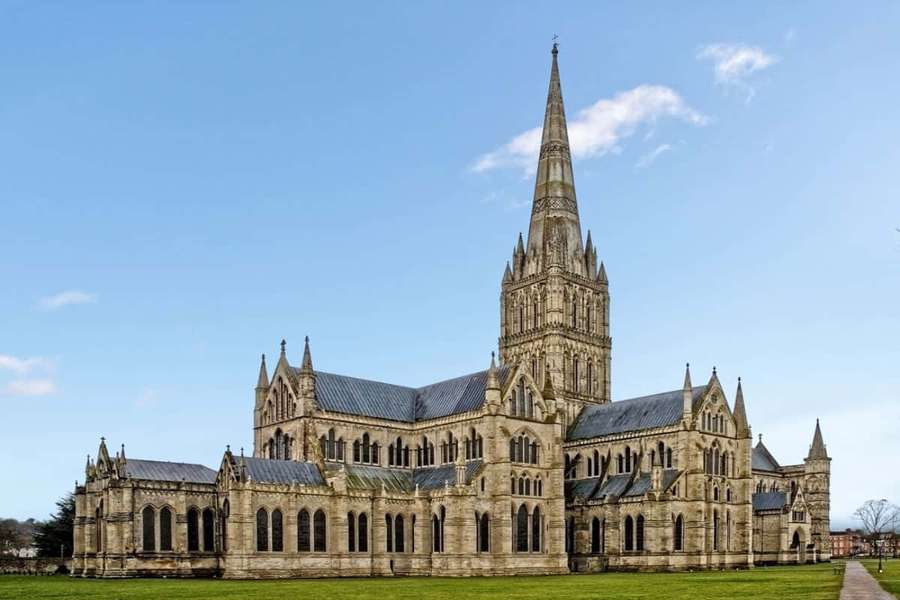 A large stone cathedral with a tall spire under a blue sky. — Salisbury Wallpaper