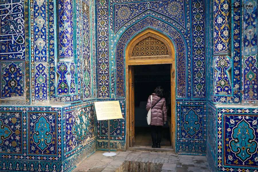 Besucher betritt eine verzierte blau gekachelte islamische Architekturtür. — Samarkand Bilder