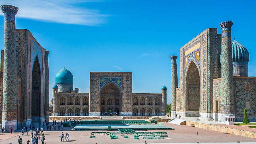 Grand mosque complex with turquoise domes and visitors in a sunlit plaza. — Samarkand Wallpaper