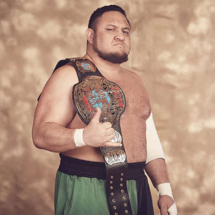 Wrestler holding championship belt and giving thumbs up in studio — Samoa joe Wallpaper