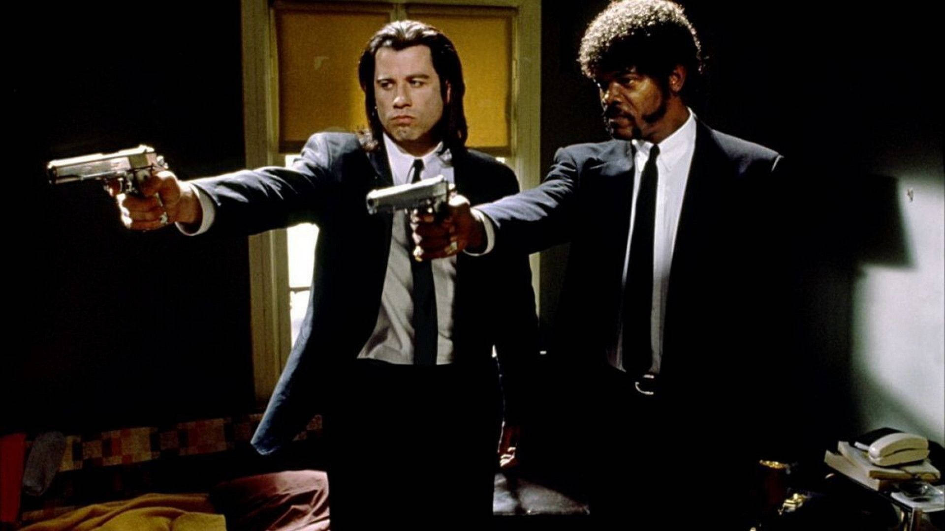 Two men in suits pointing guns in a dark room with dramatic lighting. — Samuel L Jackson Background