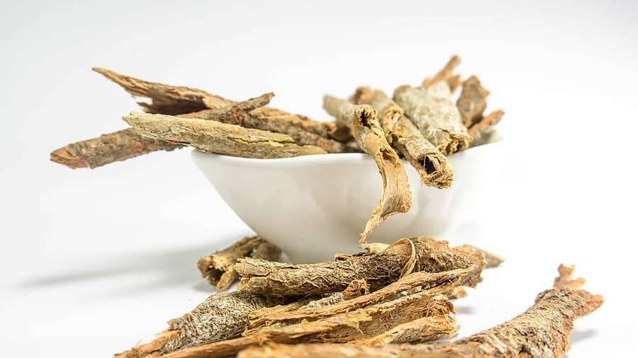 Palitos de canela secos en un tazón blanco con piezas esparcidas alrededor. — Sanador Fondos de pantalla