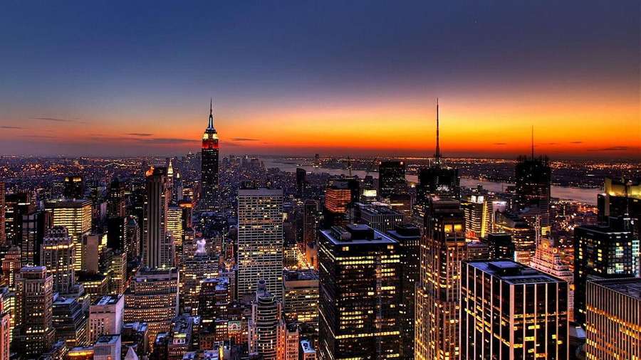 Skyline von New York City in der Dämmerung mit beleuchteten Wolkenkratzern und orangefarbenem Himmel. — Sao Paulo Bilder