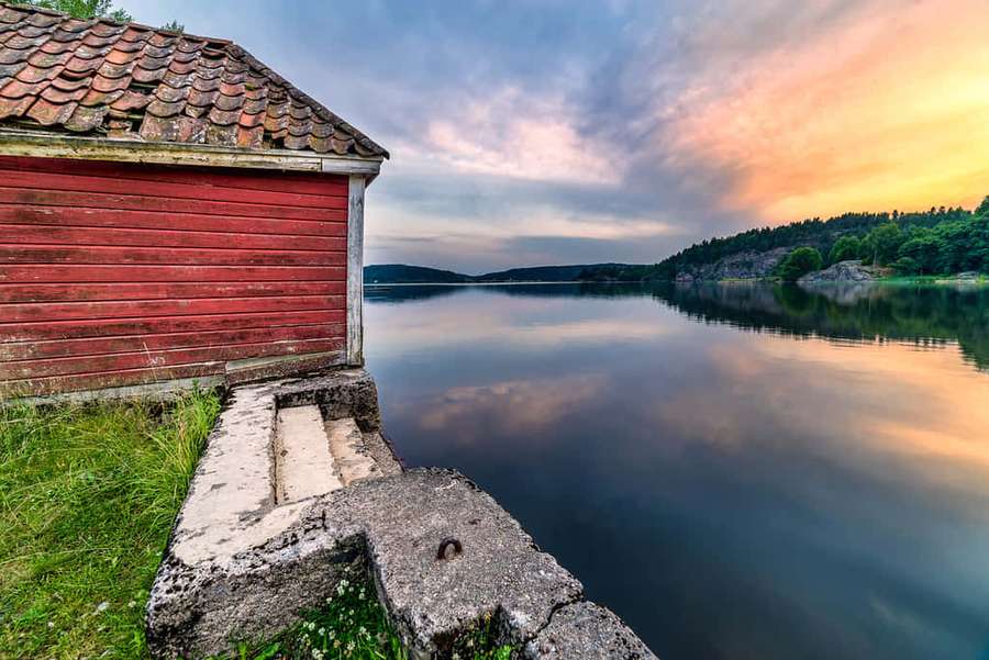 Pondok kayu merah di tepi danau saat senja dengan pantulan air tenang — Sarpsborg Wallpaper
