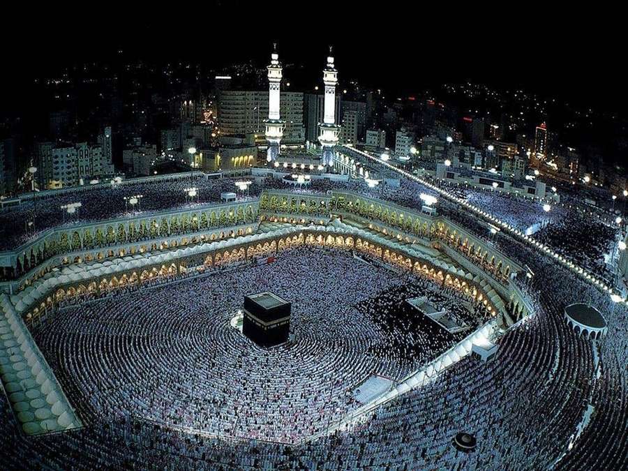 Massenhafte Menschenmenge, die nachts die Kaaba in Mekka unter hellem Licht umkreist. — Saudi Arabien Wallpaper