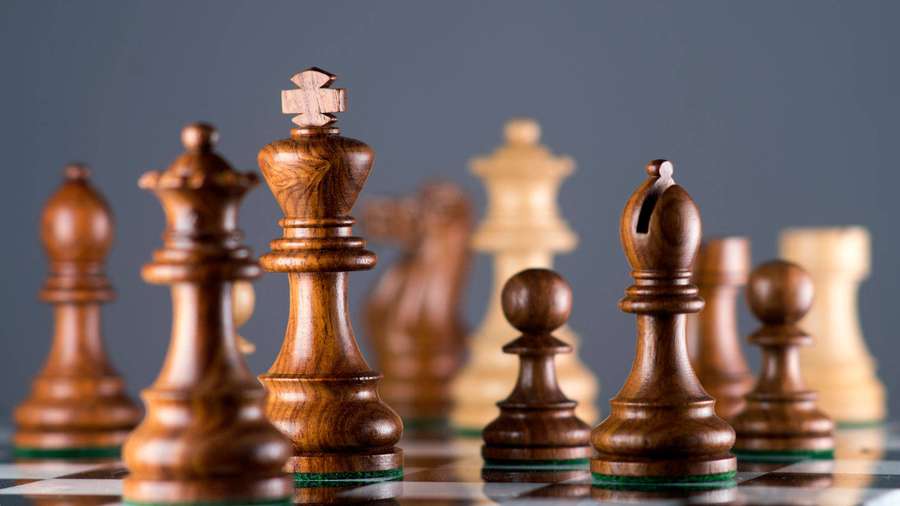 Hölzerne Schachfiguren auf einem karierten Brett mit selektivem Fokus. — Schach Wallpaper
