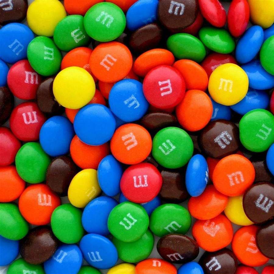 Ein Haufen bunter M&M's Süßigkeiten mit weißen m-Logos. — Schokolade Wallpaper