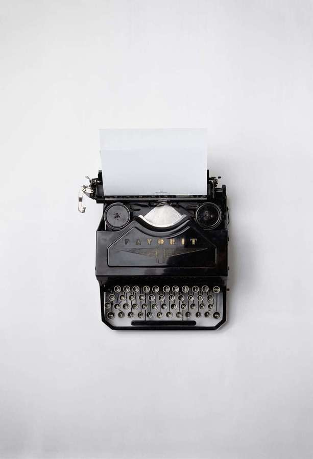 Vintage schwarze Schreibmaschine mit leerem Papier auf weißem Hintergrund — Schwarzer Retro Wallpaper
