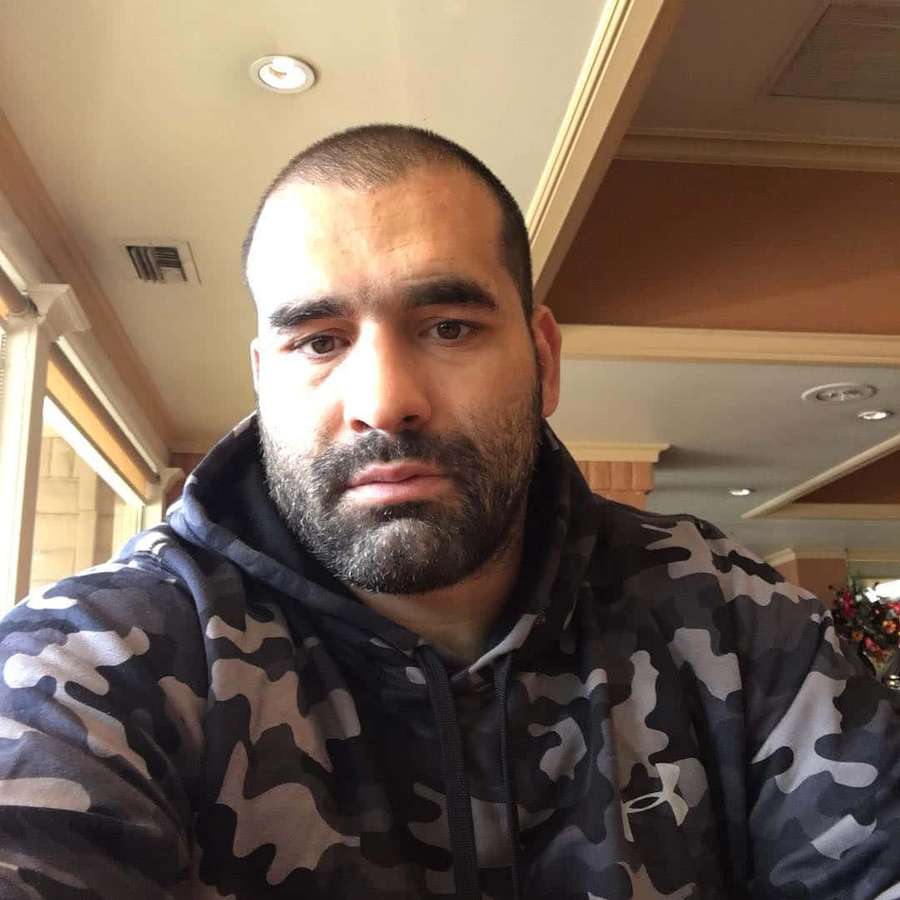 Mann mit Bart trägt Camouflage-Kapuzenpullover drinnen — Selfie Mann Wallpaper