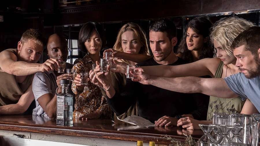 Seitsemän hengen ryhmä maljaa shot-laseilla pimeässä baarissa. — Sense8 Taustakuvat