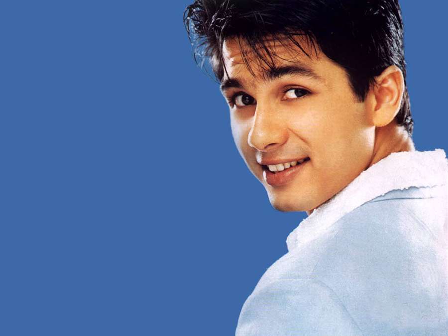 Young man smiling over shoulder in studio portrait with blue background — Shahid Kapoor Wallpaper