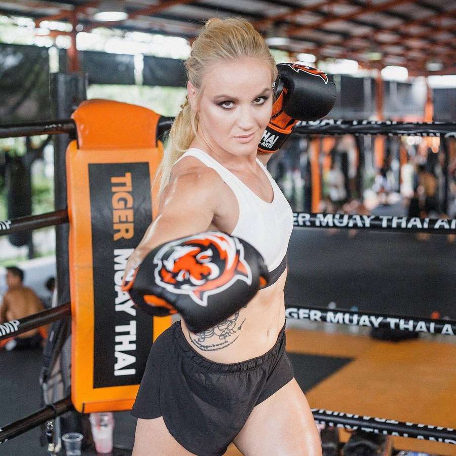 Blonde Frau in Boxhandschuhen posiert in einem Muay-Thai-Ring. — Shevchenko Bilder