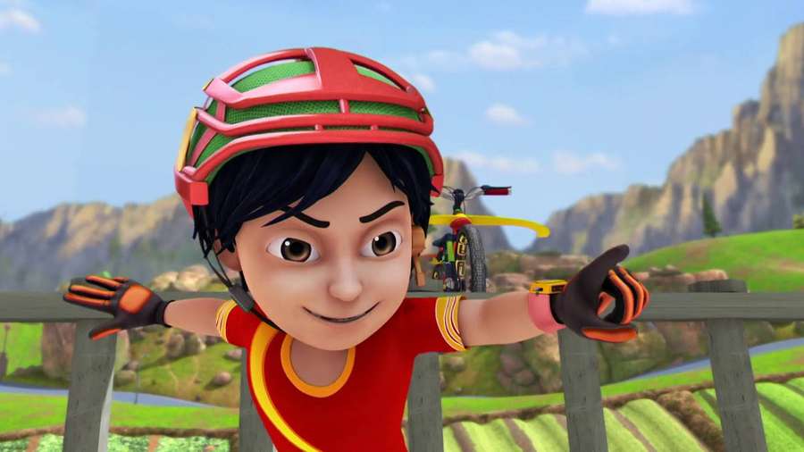 Animated boy in red helmet smiling over wooden fence with mountain valley behind. — Shiva Cartoon Wallpaper