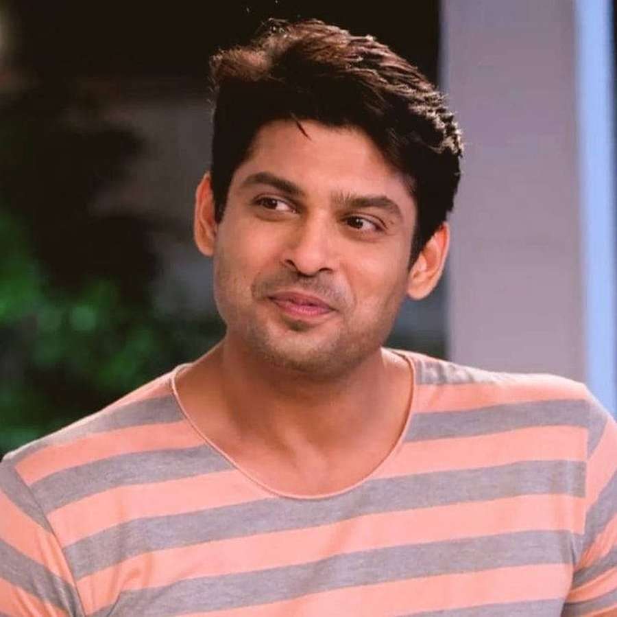 Man in peach and gray striped shirt smiling slightly indoors — Sidharth Shukla Background