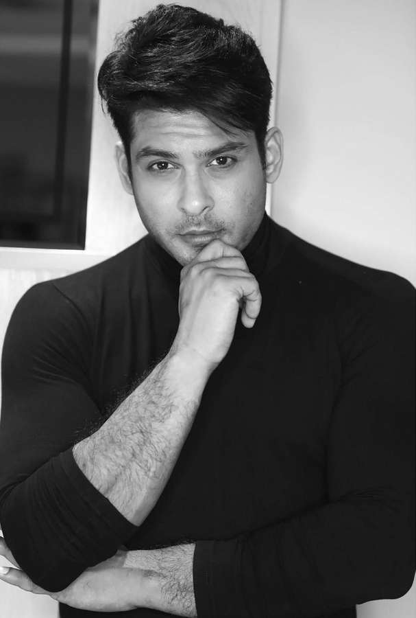 Mann im schwarzen Rollkragenpullover, nachdenklich posierend mit der Hand am Kinn. — Sidharth Shukla Bilder