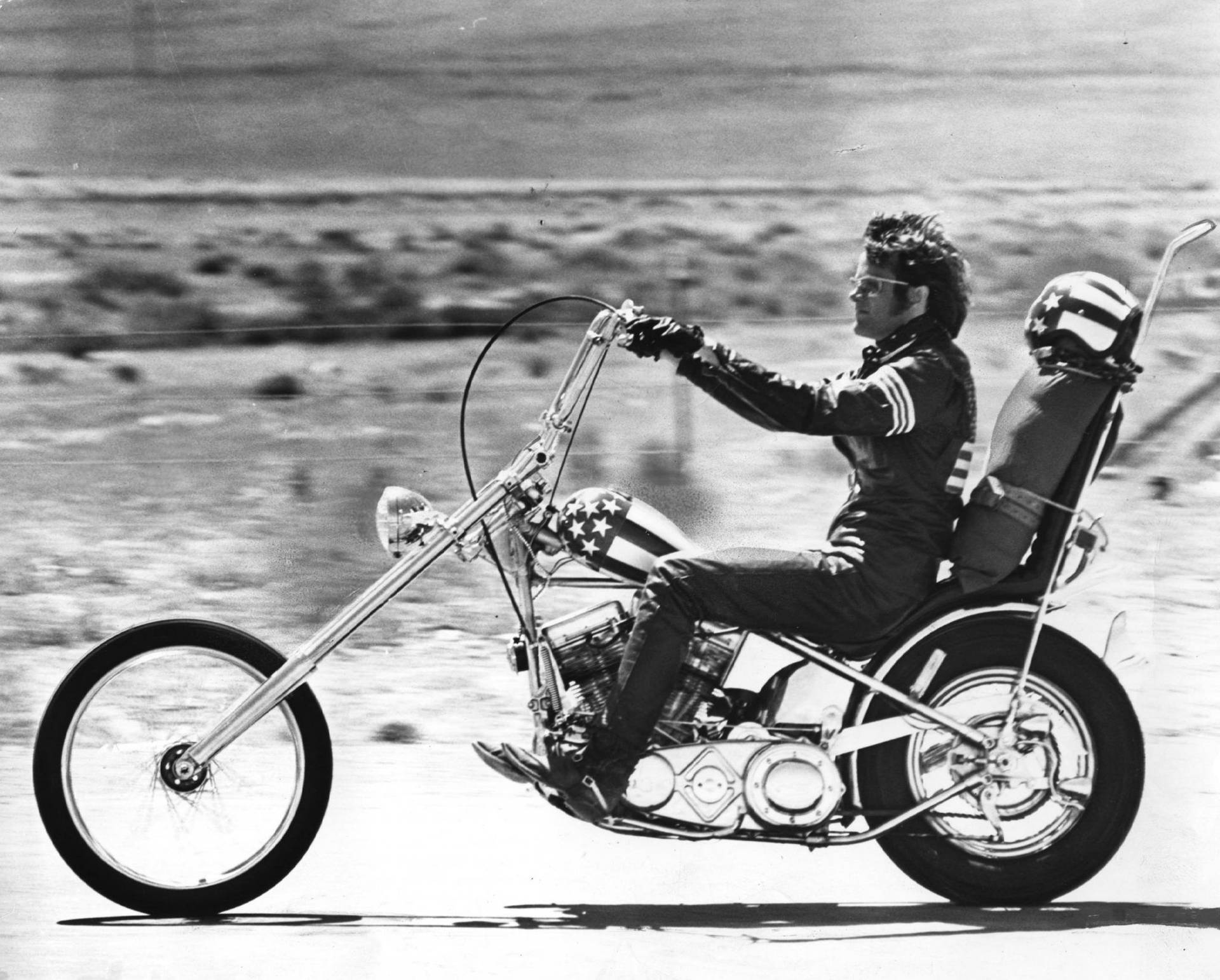 Motorcyklist på specialbyggd chopper-motorcykel kör över öknen vid solnedgång. — Enkla bilder Bakgrundsbilder