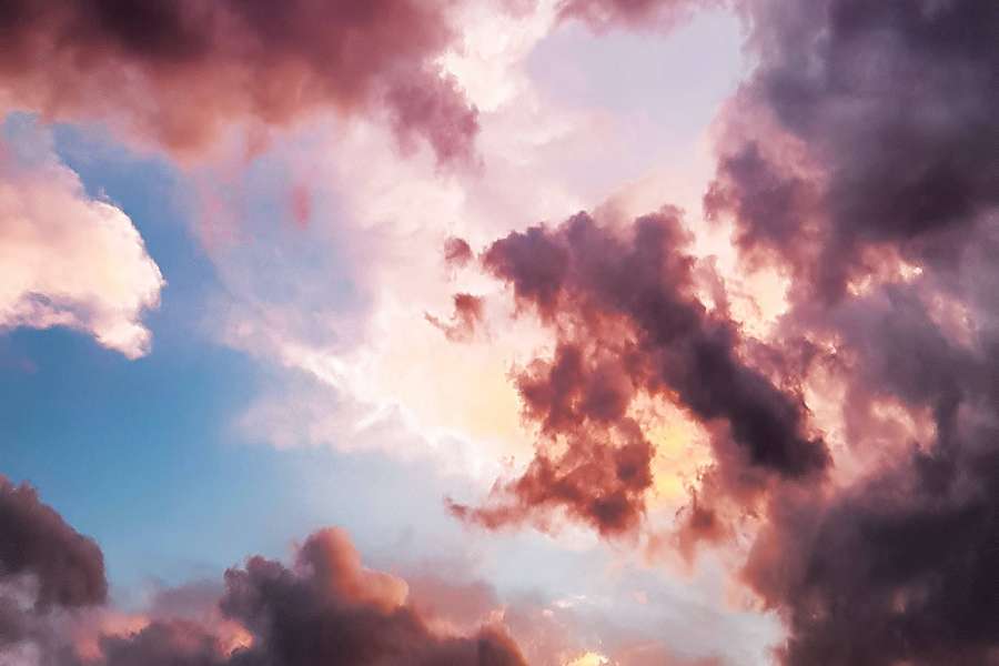 Pink and purple clouds glowing at sunset against a blue sky — Sky Background