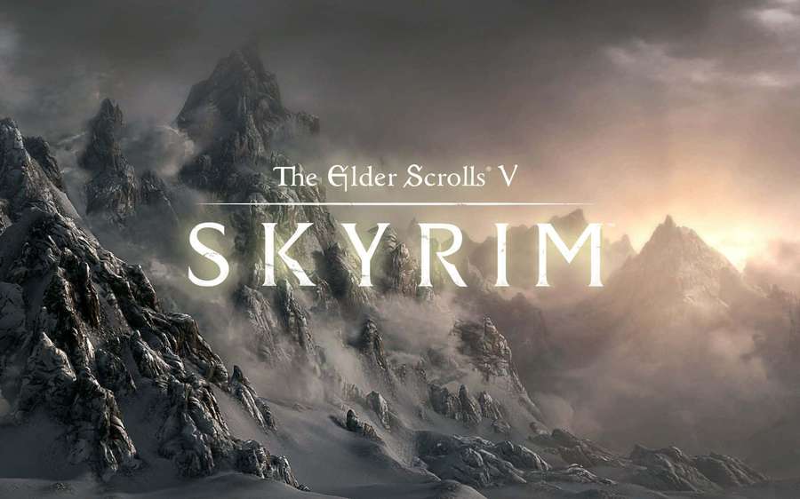 Snowy mountain range with game title Skyrim glowing in sunset light. — Skyrim Desktop Wallpaper