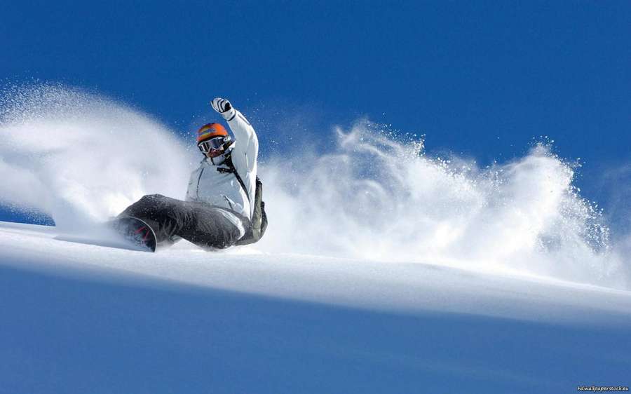 Snowboarder fährt eine verschneite Piste hinunter, Schnee spritzt auf — Snowboard Bilder