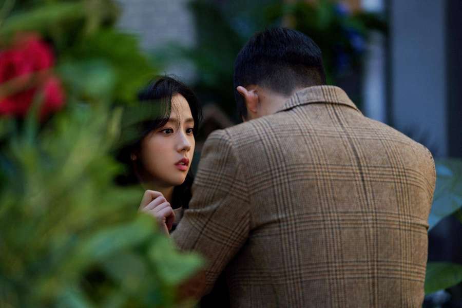 Woman observing man in plaid jacket through green foliage. — Snowdrop Wallpaper