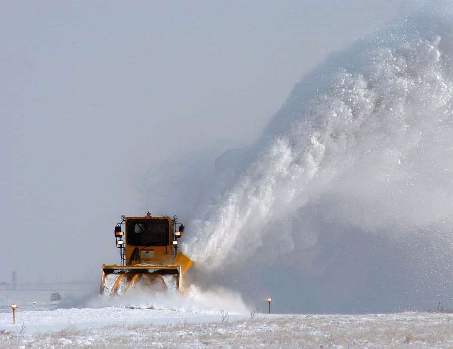 Yellow snowplow clearing snow in a winter field. — Snowplow Wallpaper
