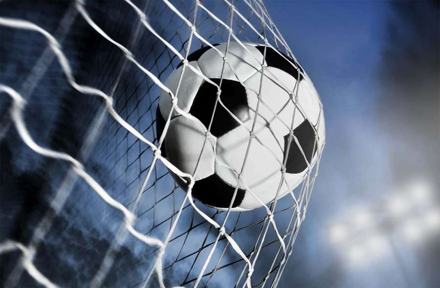 Soccer ball caught in goal net under bright stadium lights. — Soccer Picture