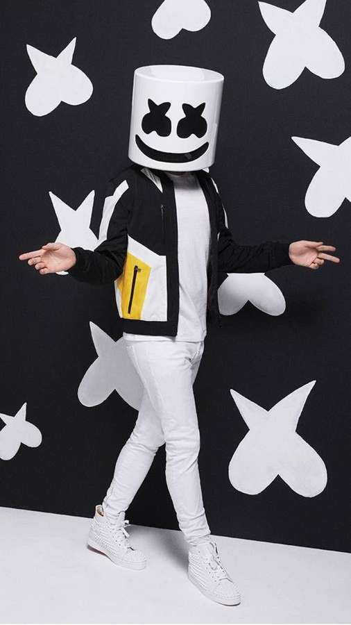 Person iført Marshmello-hjelm og sort jakke poserer foran en væg med hjerte-mønster. — Sort Marshmello Wallpapers
