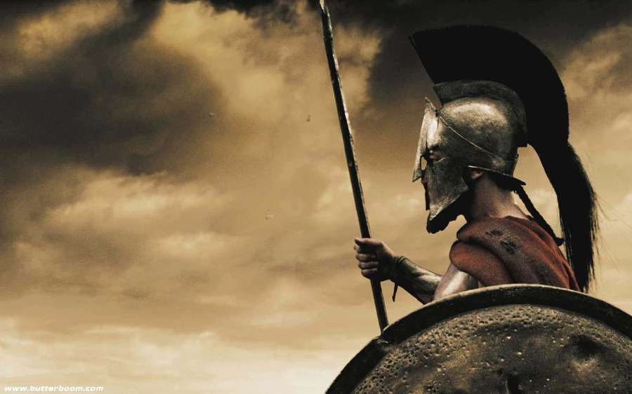 Spartan soldier in armor holding spear and shield under stormy sky — Spartan Wallpaper
