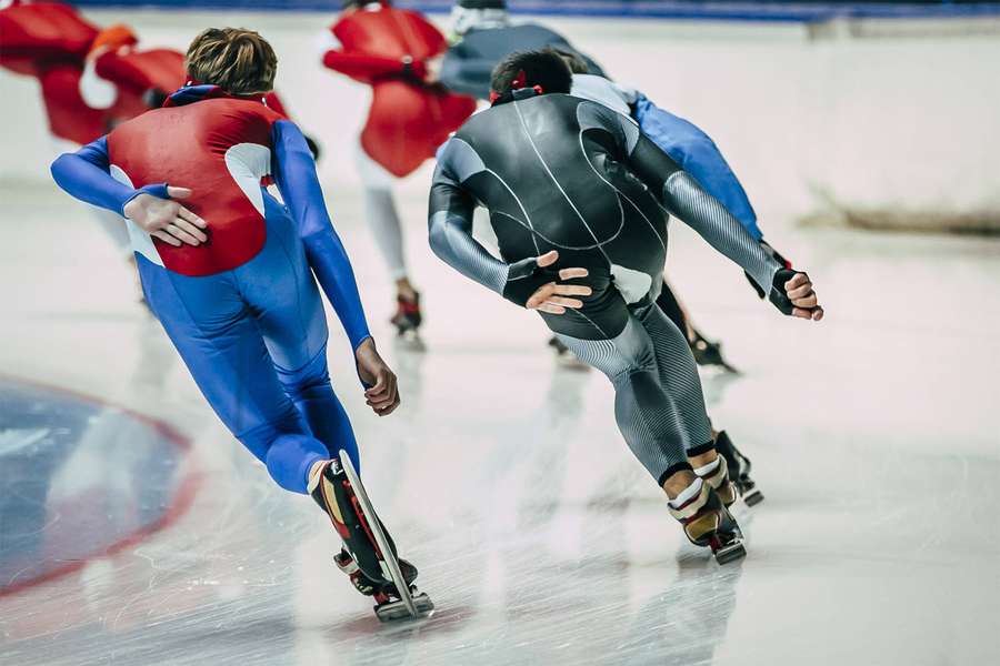 Athletes racing on ice skates in a competitive indoor speed skating event. — Speed Skating Wallpaper