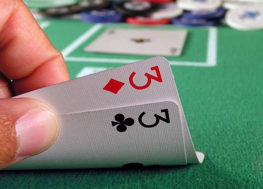 Hand, die zwei drei Spielkarten auf einem grünen Kasinotisch mit Chips hält. — Spielkarten Bilder Wallpaper