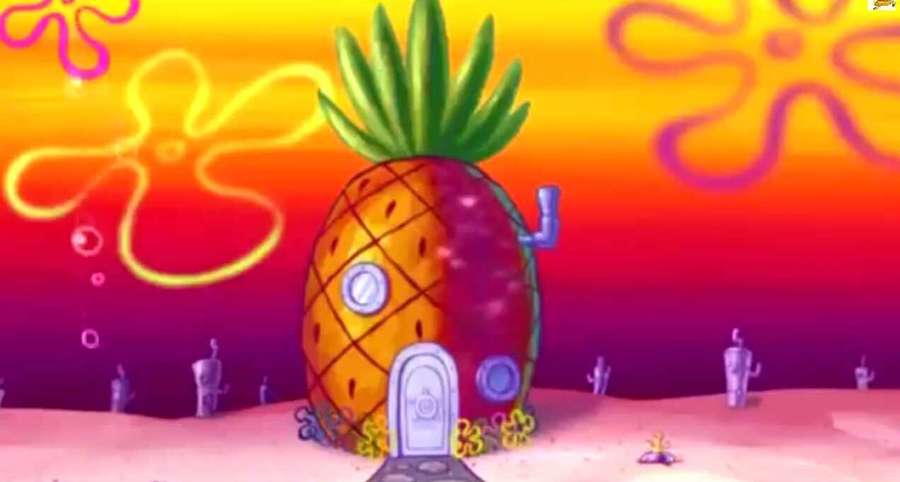 A pineapple-shaped house with a blue door on an ocean floor at sunset. — Spongebob House Wallpaper