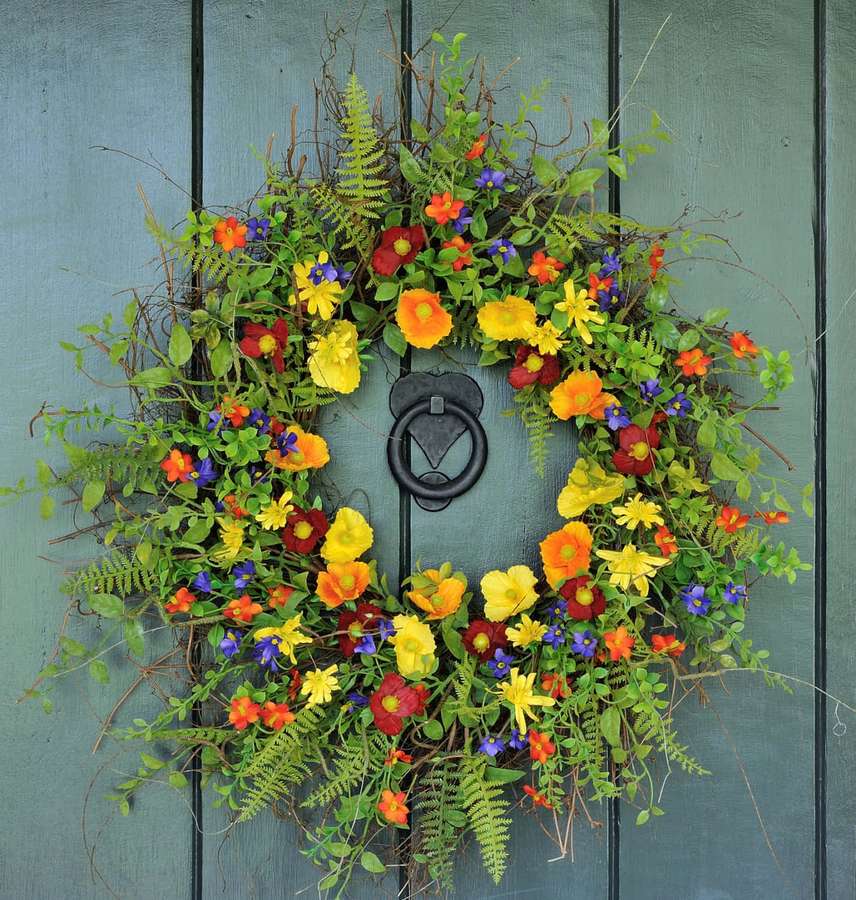 Colorful floral wreath with ferns on a teal wooden door with black knocker. — Spring Wreaths Wallpaper