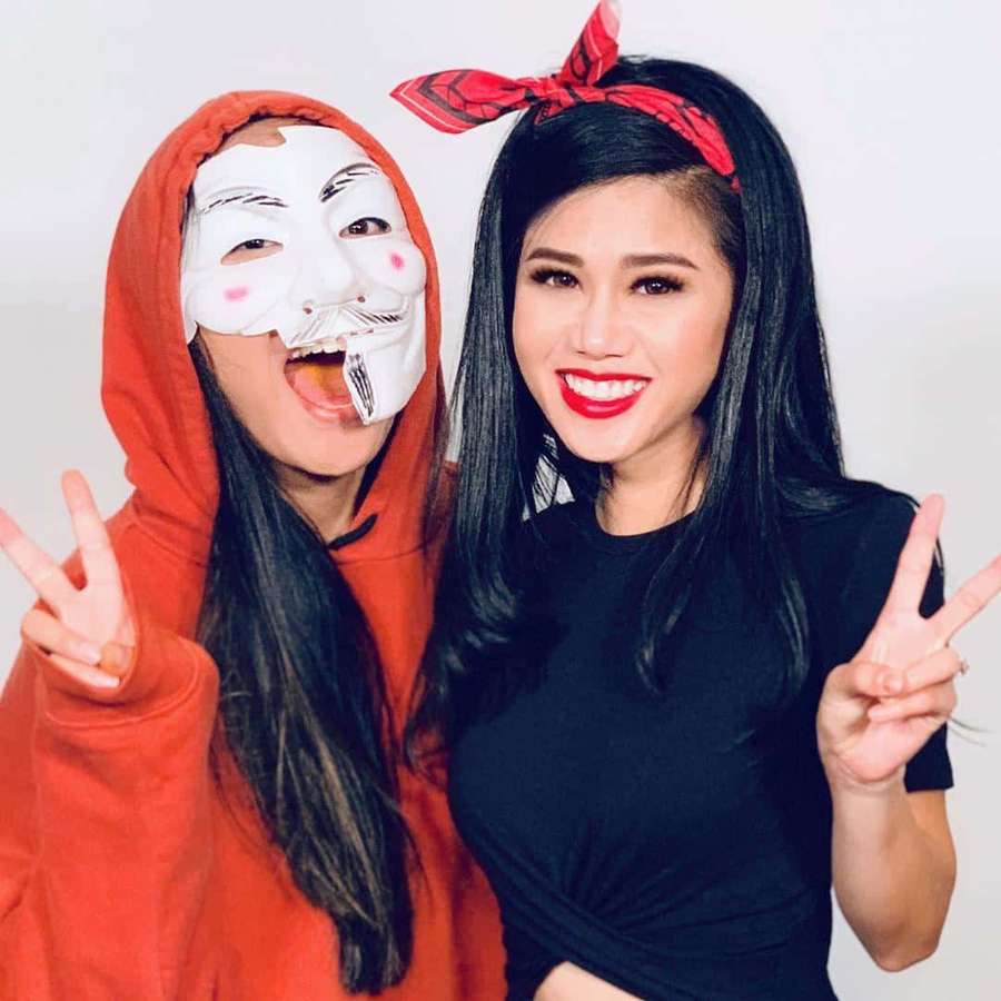 Zwei Frauen posieren mit Friedenszeichen, eine in rotem Kapuzenpulli mit Maske, die andere in schwarzem Top mit rotem Bandana. — Spy Ninjas Bilder