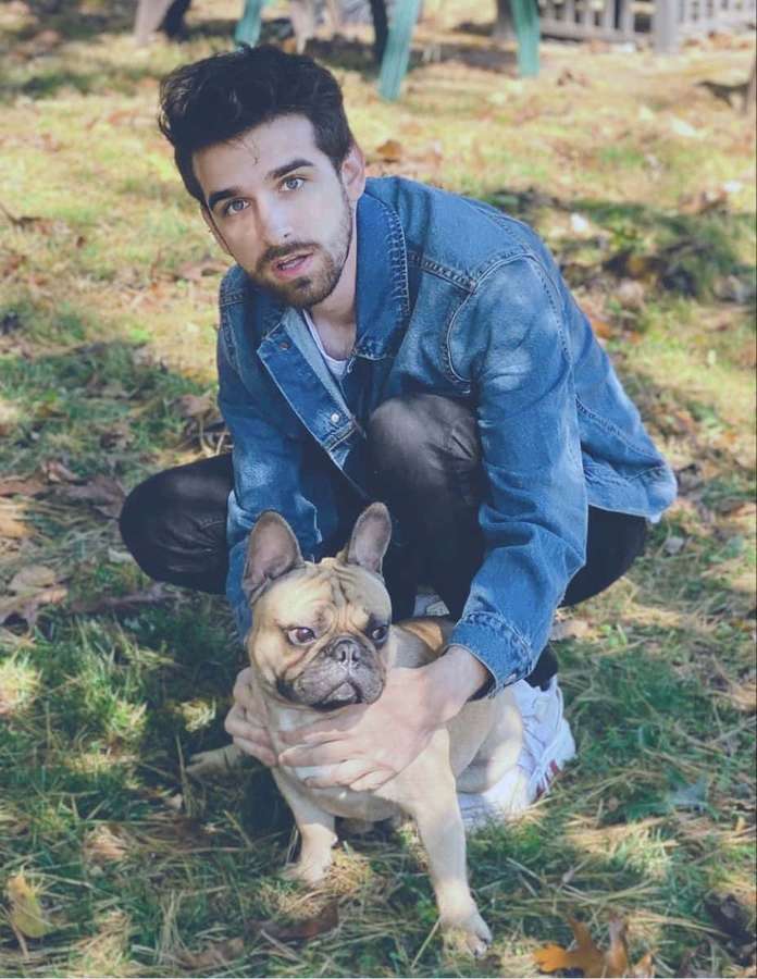Joven sosteniendo un bulldog francés sobre el césped. — Spy Ninjas Fondos de pantalla