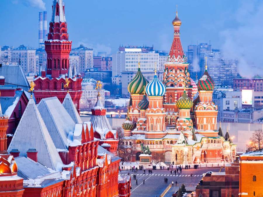 Basilius-Kathedrale in Moskau bei Sonnenuntergang mit Schnee bedeckt, Stadtgebäude im Hintergrund. — St. Basil's Cathedral Wallpaper