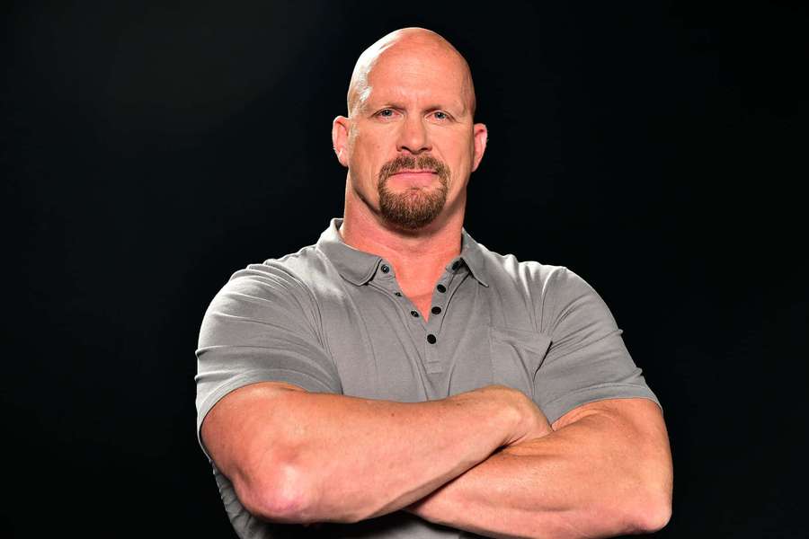 Hombre musculoso calvo con perilla vistiendo camisa polo gris brazos cruzados en estudio — Steve Austin Fondos de pantalla