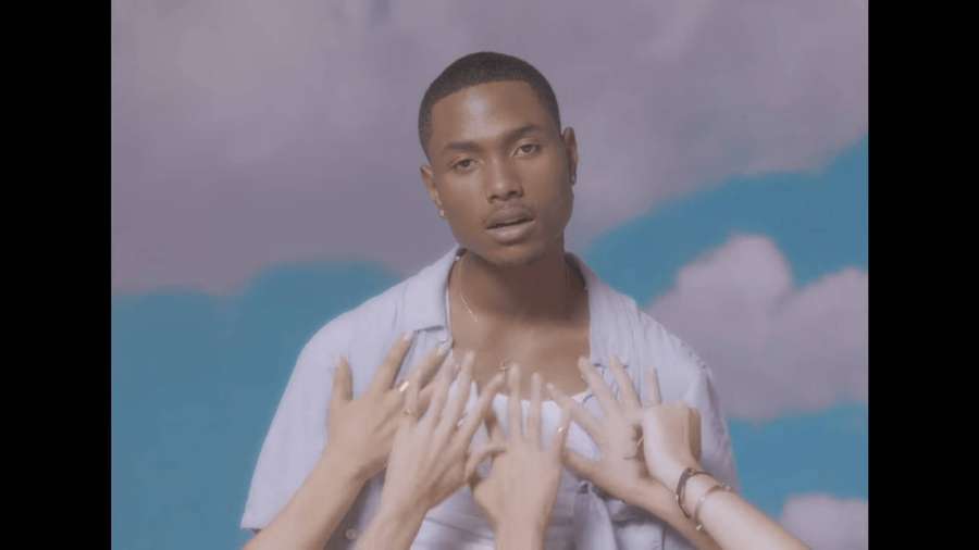 A man in a light shirt with hands reaching toward him against a painted sky background. — Steve Lacy Wallpaper