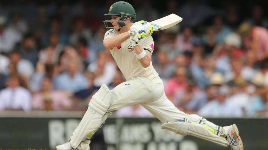 Cricket player swinging bat during daytime match with crowd behind. — Steve Smith Wallpaper