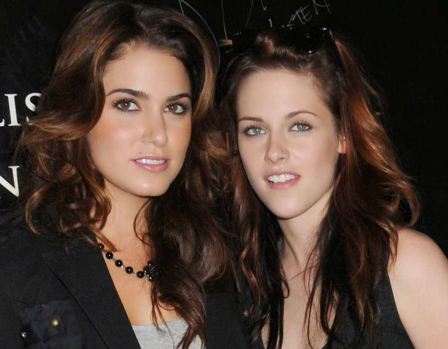 Two women posing together at an event with dark backgrounds and formal attire. — Stewart Background