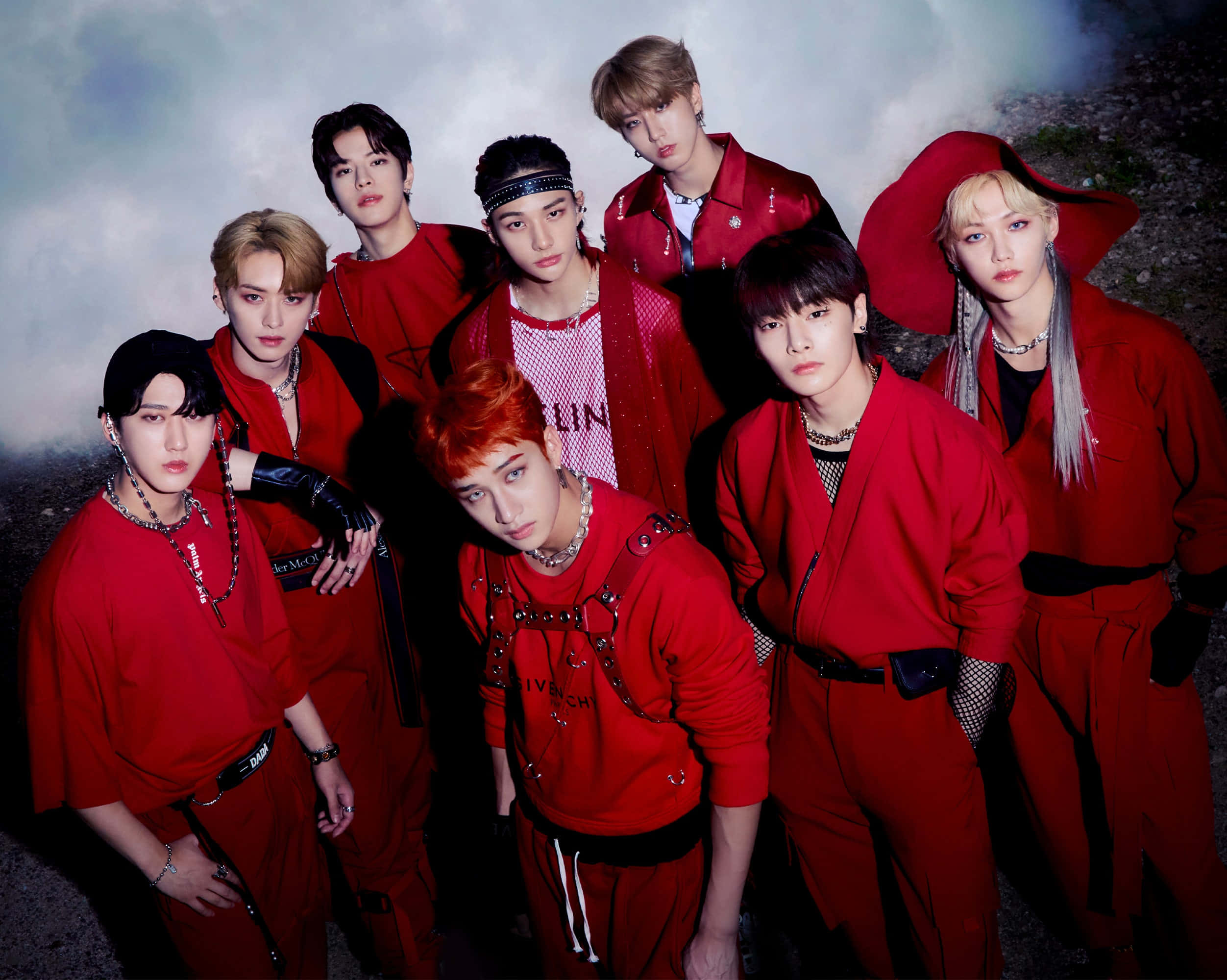 Seven K-pop idols in matching red outfits posing for a studio photo. — Stray Kids Wallpaper