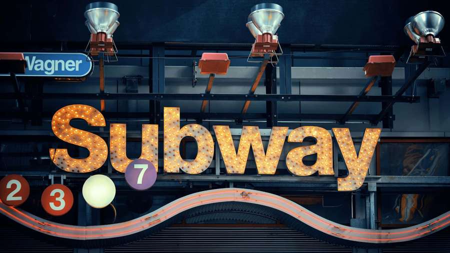 Glowing subway station sign with route numbers at night. — Subway Background