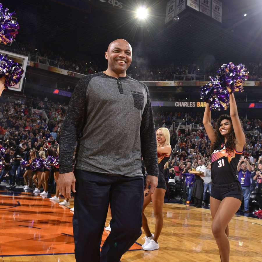 Basketball coach walking on court with cheerleaders and fans cheering. — Suns Background