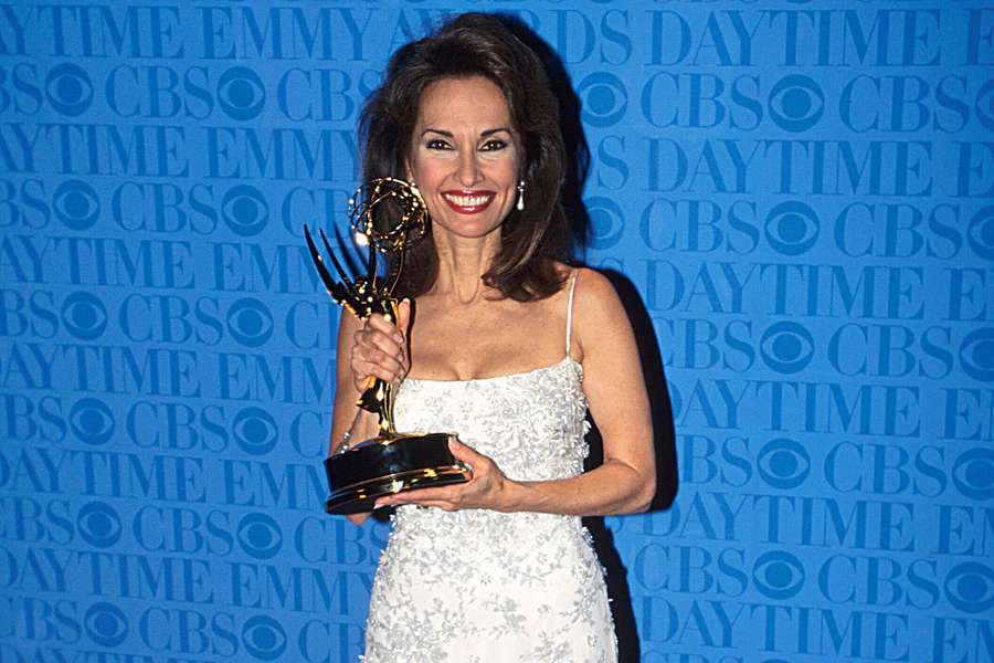 Woman in white dress holding Emmy award at CBS Daytime Emmy event. — Susan Lucci Wallpaper